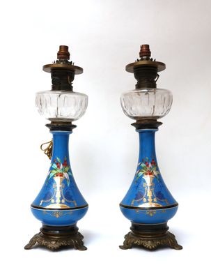 pair of blue and gold vases with glass lamps on stands