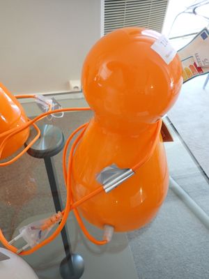 une lampe orange posée sur une table en verre