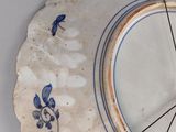 a blue and white plate with a clock on it
