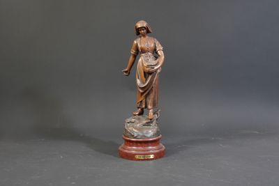bronze statue of a woman holding a basket on a marble base