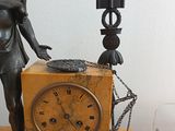a statue of a woman holding a clock on a table