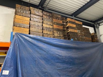 a large pile of wood stacked on top of a blue tarp