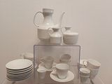 beaucoup d'assiettes et de tasses blanches posées sur une table en verre