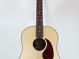 an acoustic guitar on a stand against a white background