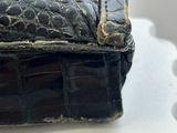 a black purse sitting on top of a white table