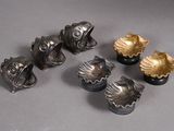 six pieces of silver and gold colored metal on a gray surface