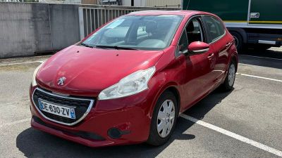une voiture rouge garée sur un parking à côté d'un camion