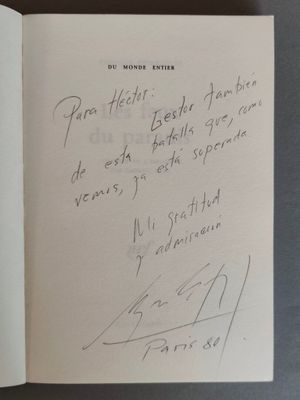 un livre ouvert, sur lequel est posée une note manuscrite, posé sur une table