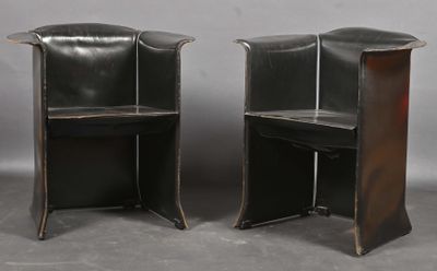 une paire de fauteuils en cuir noir avec des pieds en métal et une table en bois