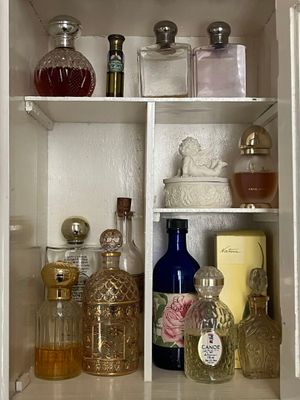 de nombreux flacons de parfum sur les étagères de la salle de bains