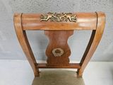 a wooden chair with a gold decoration on the back of it