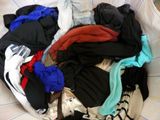 a basket full of clothes that is on a bed