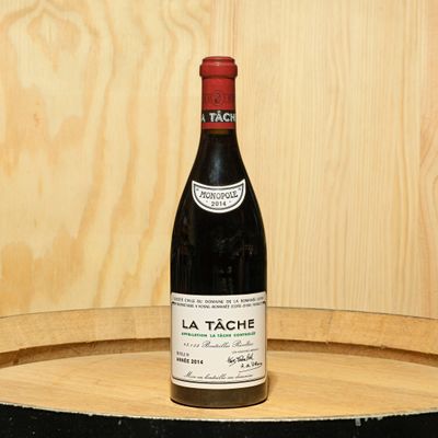 a bottle of wine sitting on top of a barrel