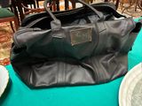 un grand sac noir posé sur une table dans une pièce