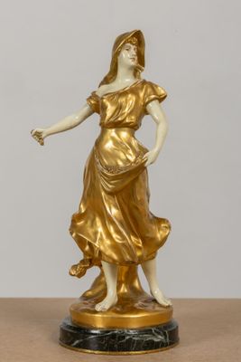 statue d'une femme vêtue d'une robe dorée et tenant une fleur