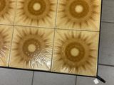 tiled floor with four different designs of sunbursts on them