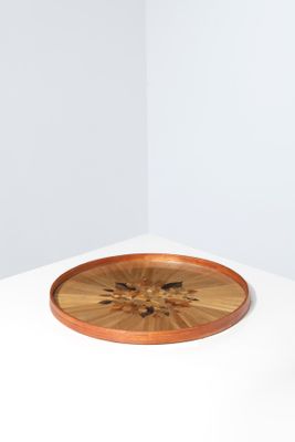 une pièce blanche et vide avec un plateau en bois posé par terre