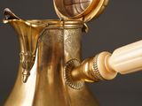 a gold vase with a wooden handle and a wooden handle