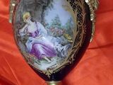 a blue vase with a painting on it on a stand