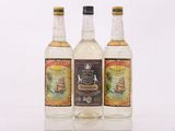 three bottles of alcohol sitting next to each other on a table
