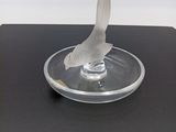 sculpture représentant un oiseau sur une plaque de verre posée sur une surface noire