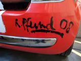 a red car that has been painted with black writing on it