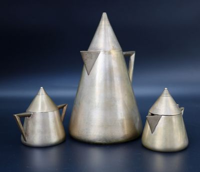 three pieces of silver metal on a blue surface