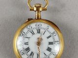 une montre de poche en or avec des chiffres romains