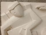a sculpture of a man sitting on top of a table