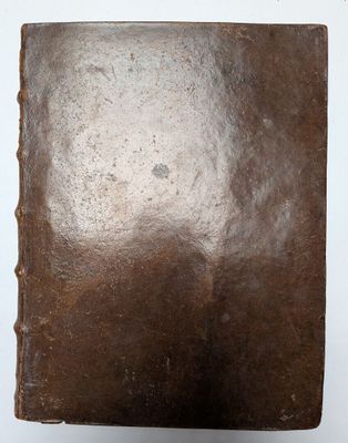 an old book sitting on top of a white surface