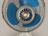 a white and blue fan sitting on top of a table