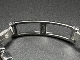 a silver bracelet with a metal clasp on a table