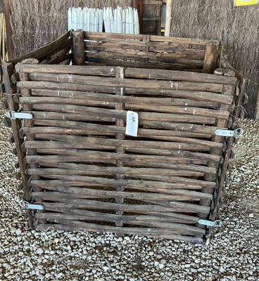 une caisse en bois sur laquelle est accrochée une étiquette, posée sur du gravier