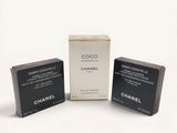 trois coffrets de parfum Chanel posés sur une surface blanche