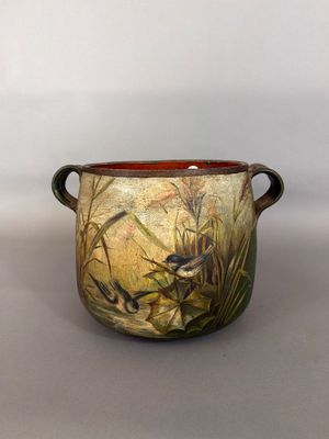 a vase with a painting on it sitting on a table