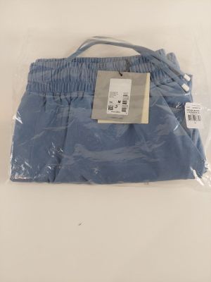 Le pantalon bleu est emballé dans du plastique et prêt à être porté.