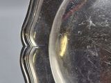 a silver plate with a man ' s face on it