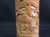 a wooden vase with carvings on it on a black background