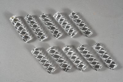 several pieces of silver metal are arranged on a white surface