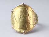 an image of a gold coin ring with a man ' s face on it