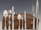 une boîte en bois sur laquelle est posé un ensemble d'argenterie