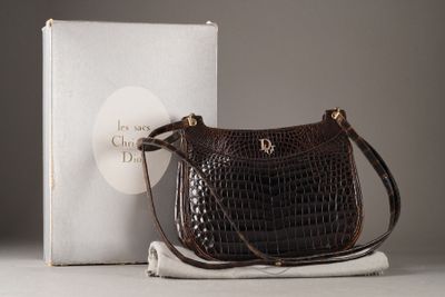 un sac à main marron posé à côté d'une boîte sur une table