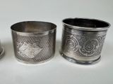 three silver cups sitting next to each other on a white surface
