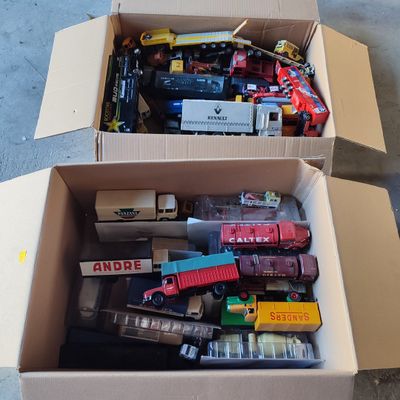 une boîte en carton remplie de petits trains et d'autres jouets