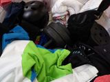 a pile of clothing and a helmet in a suitcase