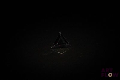 l'image d'un objet en forme de triangle dans l'obscurité