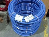 a large blue hose sitting on the floor next to other hoses
