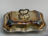 an antique silver plate with a handle on top of it