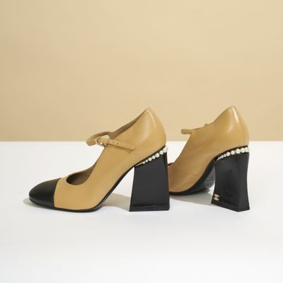 une paire de chaussures beiges et noires ornées de perles au talon