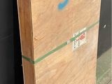 a wooden box with graffiti on it sitting against a wall